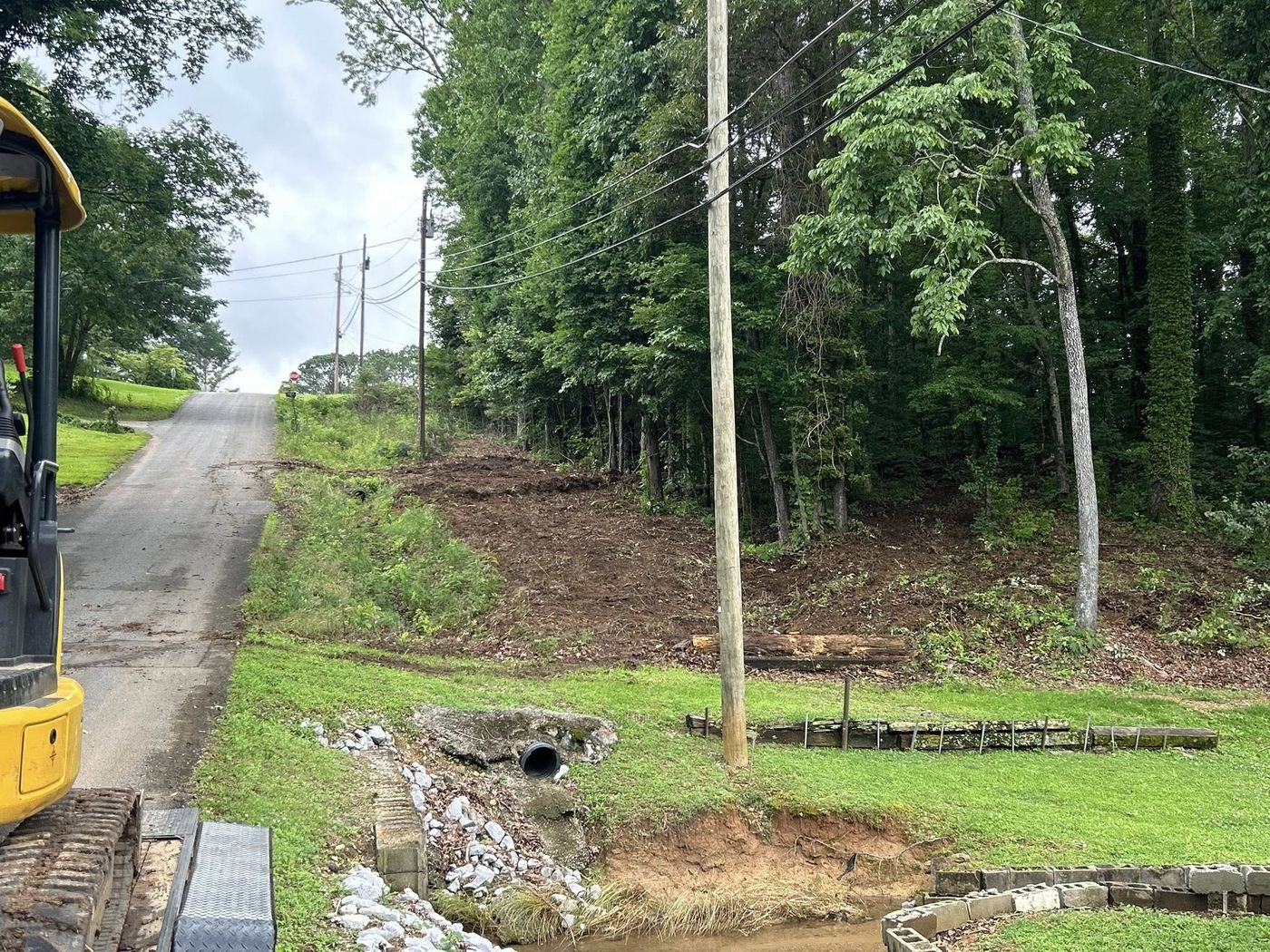 Cleared roadside bank with culvert at a driveway entrance