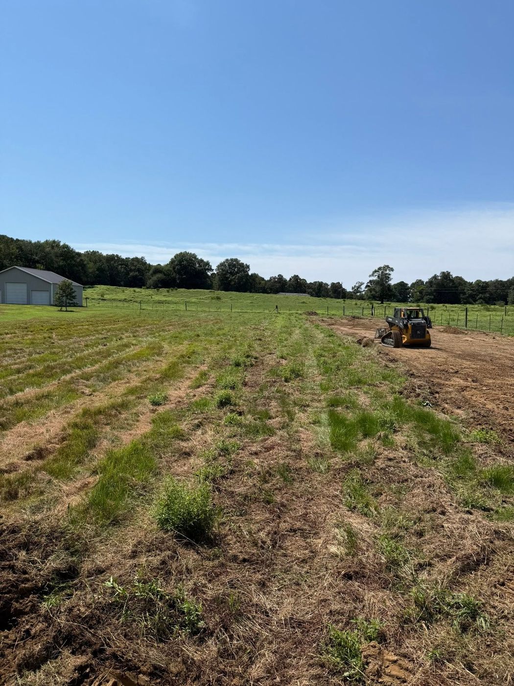 John Deere track loader spreading topsoil